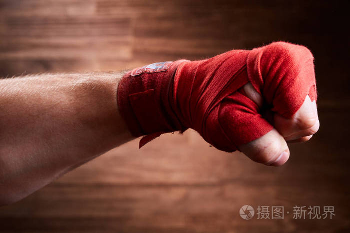 关闭的形象是一个拳击手用棕色背景红色绷带的拳头