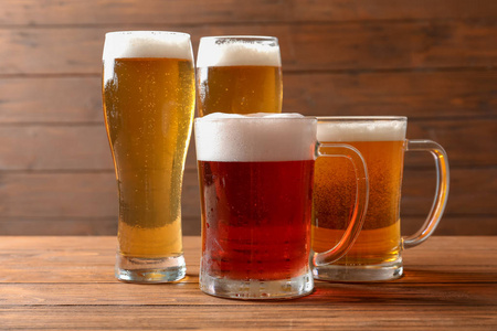 木桌上不同类型冷可口啤酒的眼镜