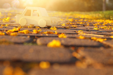 在户外在日落公园的道路上的旧木制玩具车。怀旧和简单的概念