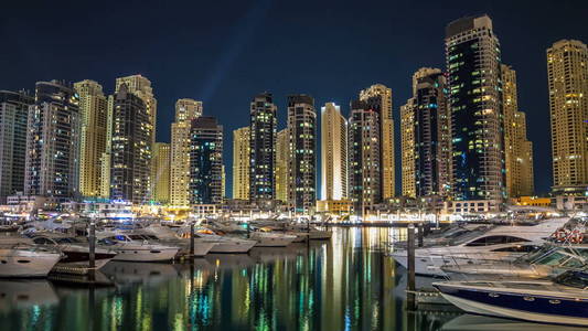 美丽的夜景从长廊在迪拜滨海塔反映在水中漂浮游艇和船只 timelapse hyperlapse, 阿拉伯联合酋长国。迪拜码头是迪
