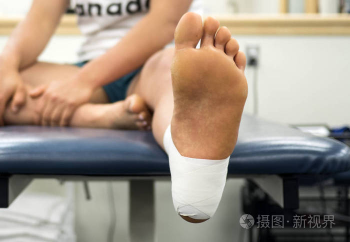 在运动员脚上关闭脚踝胶带工作的底部视图