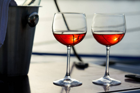 在明亮的阳光下的葡萄酒杯在游艇表面