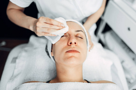 美容师手在女性病人脸上揉奶油, 顶端看, 美容诊所。水疗沙龙的面部护肤复壮程序