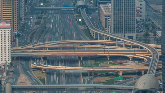 空中的顶视图的公路与交通游戏在迪拜，阿拉伯联合酋长国，在日落时的中时光倒流的交界处。著名的谢赫扎耶德路迪拜市中心。运输和驾驶概念