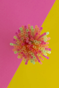 在两个色调的背景下, 对饮用吸管 霓虹灯 党的创造性看法粉红色和黄色。顶部视图