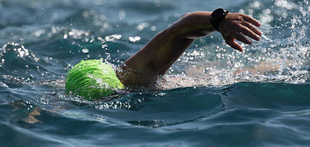 男子游泳爬行在蓝色海, 训练为铁人三项