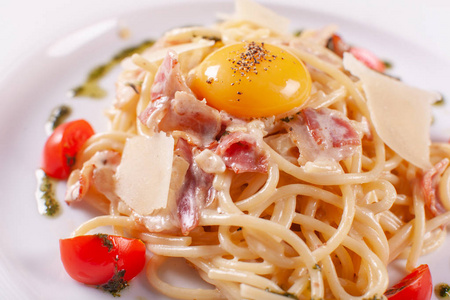 意大利面条代表。意大利面食在白色盘子与干酪, 火腿和蛋黄