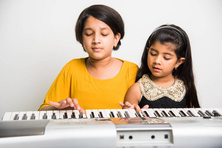 可爱小印度女孩弹钢琴或键盘，一种乐器
