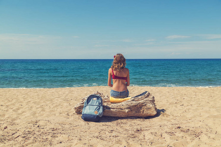 女孩坐在沙滩上看海洋风景