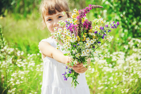 孩子带着一束野花。选择性对焦。自然