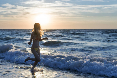 黎明时分在沙滩上奔跑的女人