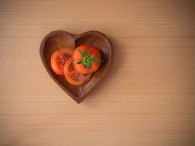 新鲜的番茄在心形状实木板图片