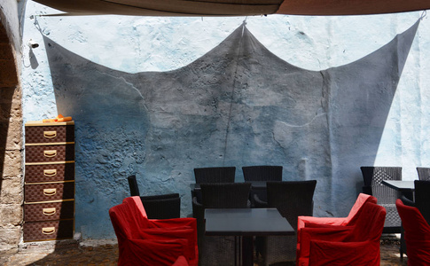 在摩洛哥马拉喀什老镇桌子和椅子空咖啡露台的街景