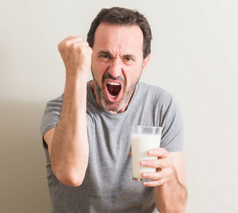 老人喝了一杯牛奶懊恼和沮丧的呼喊与愤怒, 疯狂和叫喊与举手, 愤怒的概念