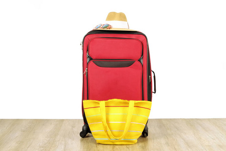 单红色耐用的纺织品行李与妇女的草帽, 太阳镜, 黄色沙滩袋。一个行李箱。独自旅行的概念。白色纹理背景, 复制文本空间, 关闭