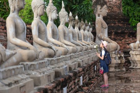 亚洲女孩旅游持有莲花尊重或祈祷在艾 Chaimngkol, 大城府, 泰国, 暑假, 旅游概念