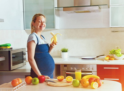 孕妇在厨房里吃香蕉
