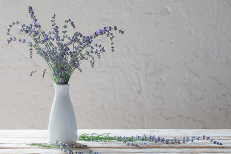 木制桌上的白色花瓶里的薰衣草