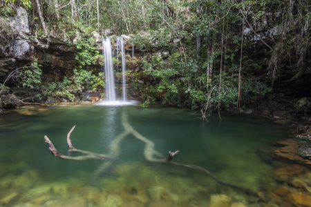 风景秀丽的塞拉多瀑布与水晶清澈的绿色水和树日志在自然, Chapada dos Veadeiros, 戈亚斯州, 巴西中部