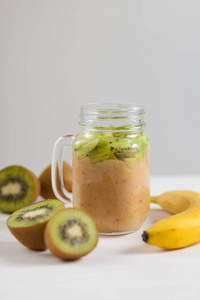 新鲜的健康果汁从猕猴桃 香蕉和苹果在白色背景上的一个罐子里。素食的食物