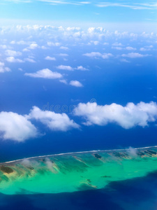 穿过云层的海洋环礁。天线景观在阳光明媚的日子里