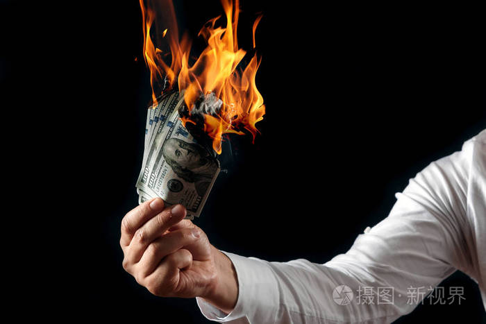男手特写, 手里拿着烧钱, 烧美元。黑色背景, 隔