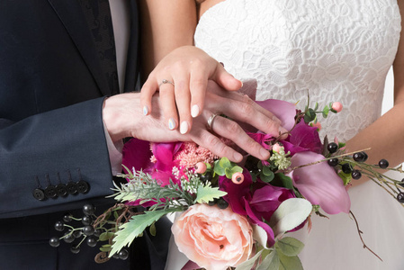 新娘和新郎的手的美丽婚礼花束关闭视图