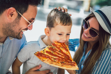幸福的家庭花时间待在比萨店的肖像