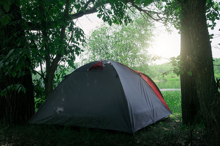 在绿色的夏天森林中露营的帐篷