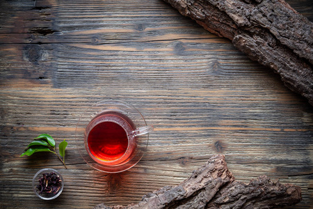 杯茶与新鲜的茶叶在老式的木质背景, 平躺拍摄