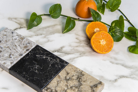 用花岗岩大理石和石英天然石材制成的厨房台面的方形样品的橘子。此图像可用作平铺或计数器颜色示例