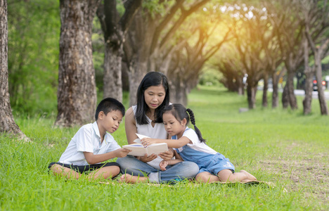 亚洲家庭, 母亲, 儿子和女儿在公园读书活动