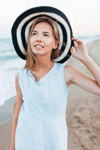 美丽的肖像女孩在帽子特写, 休息在海或海洋, 一个女人在夏天蓝色礼服