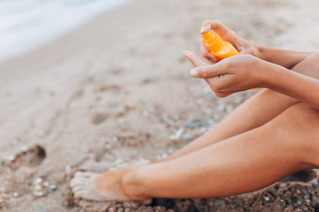 美丽的女孩, 阳光奶油应用, 在海滩上, 脚特写, 太阳霜罐子