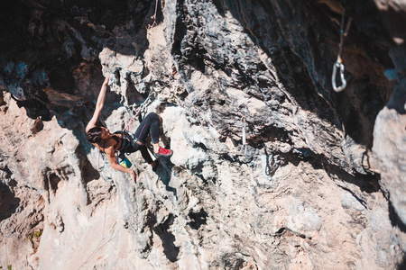 一个女人爬上岩石。攀登自然。户外健身。积极的生活方式。极限运动。运动员在自然的救济下训练。在土耳其攀岩