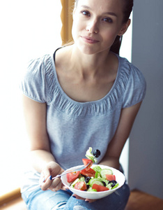 一个漂亮的女孩吃健康的食物。漂亮女孩