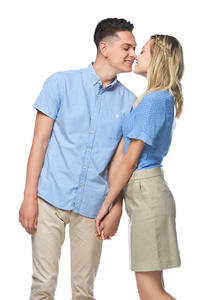 微笑的情侣在蓝色的衬衫亲吻在白色的孤立