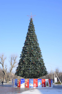 装饰新年树。圣诞圣诞树上的金属丝玩具球和其他装饰品站在露天