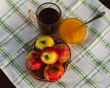 杯茶, 苹果, 蜂蜜。美味和健康的早餐在白色桌布上。农村理念