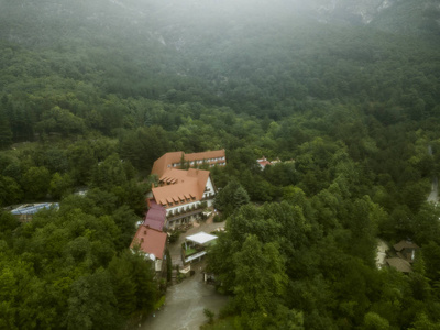 在森林里的山欧洲村庄房子之上的黑暗的雾雨的云彩