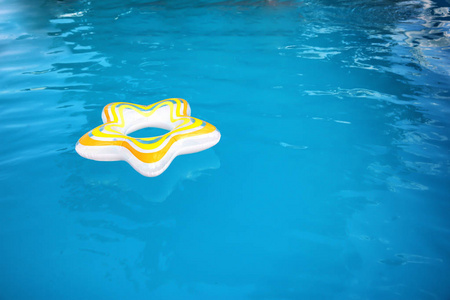 在阳光明媚的日子里漂浮在游泳池里的充气环