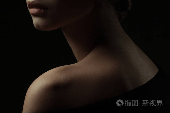 特写肖像的华丽的年轻女子与美丽的颈部黑色背景.工作室拍摄