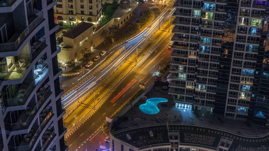 迪拜码头和金宝荣空中 timelapse, 阿联酋夜景照明。现代摩天大楼和住宅建筑。道路上的交通和发光的窗户