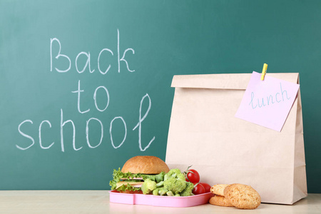 学校午餐与纸袋子在黑板背景图片
