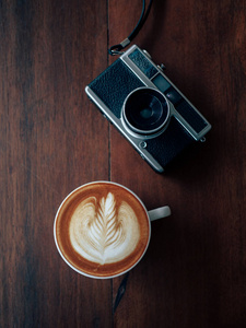 咖啡店咖啡厅的咖啡杯艺术和老式相机的顶级视图