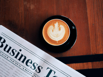 咖啡店咖啡厅的咖啡杯艺术和新闻报纸的顶级视图