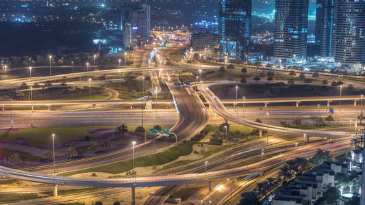 在一个大城市的夜晚 timelapse 的道路交叉路口的鸟瞰图。阿联酋迪拜滨海区城市景观与汽车摩天大楼和地铁线