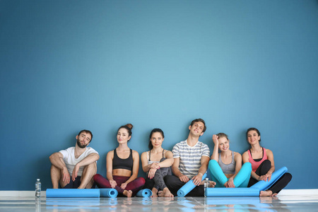 一群人, 瑜伽垫坐在地板附近的彩色墙