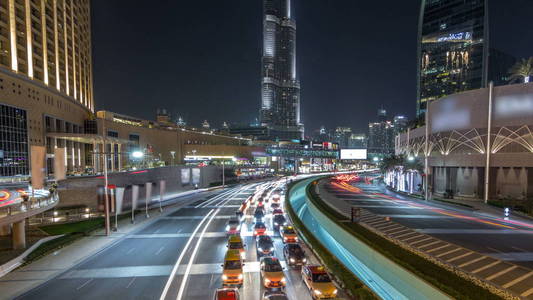 在 timelapse hyperlapse 市中心, 夜间在购物中心附近的汽车交通。摩天大楼与夜间照明。从桥上查看。阿联酋迪拜