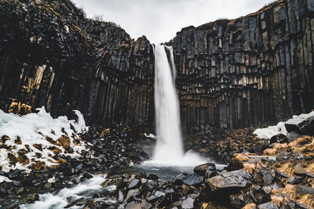 戏剧性的清晨景色著名的 Svartifoss 瀑布。五彩缤纷的夏日日出在 Skaftafell, Vatnajokull 国家公